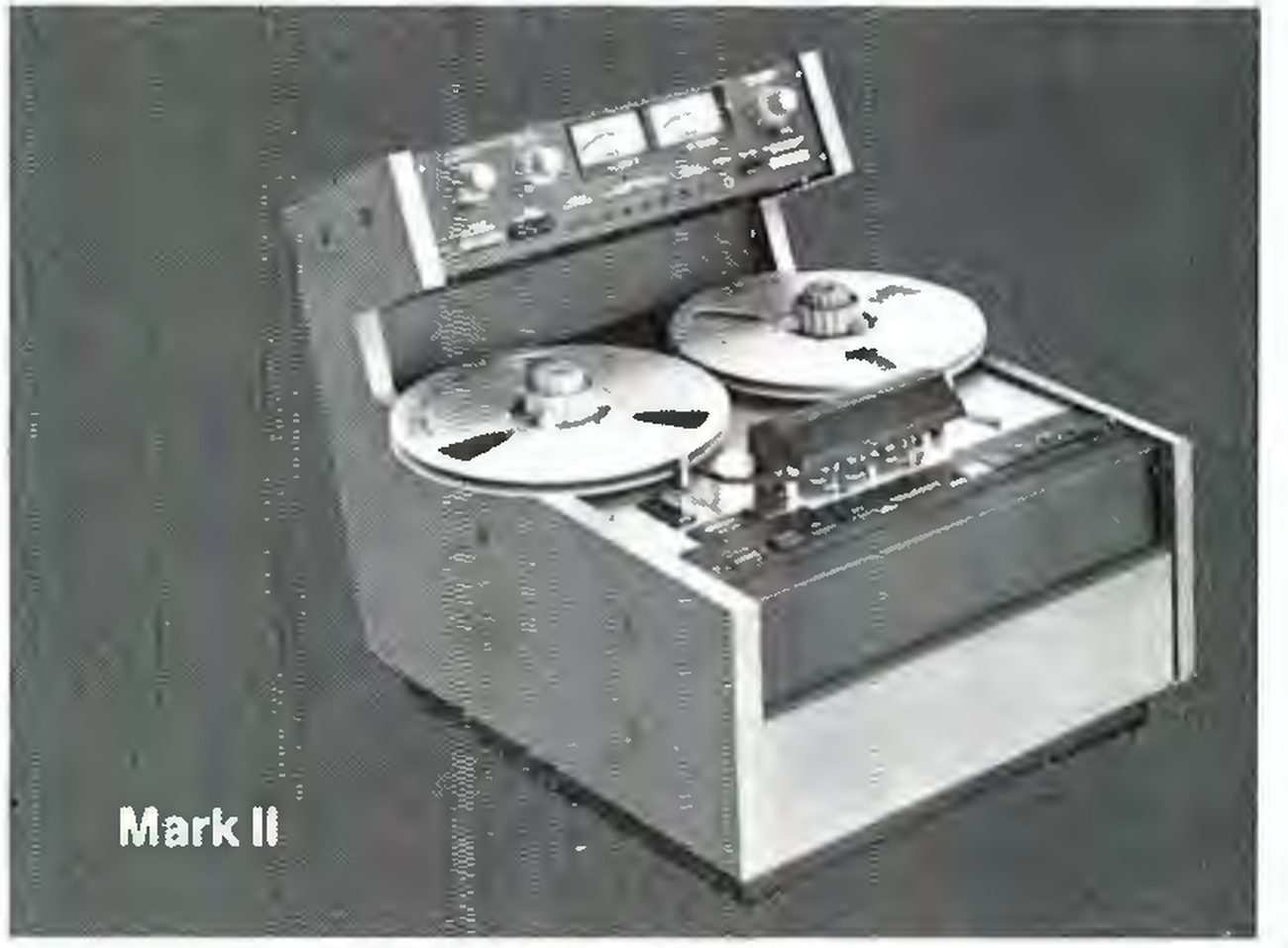 The Mark II transport in a wooden console cabinet with its meter bridge raised behind the reels, labelled Mark II.