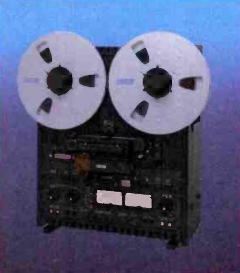 The 5050 BII standing upright against a blue backdrop, photographed from the front: two reels, the transport and the electronics panel with its pair of meters below.