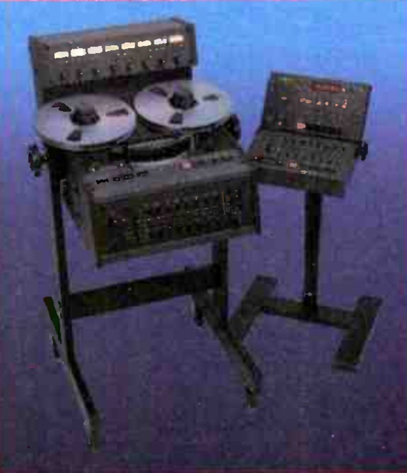 The MARK III/8 on its floor stand: the transport with two reels, a meter bridge of eight level meters above it, and the remote controller on a separate pedestal stand at the right.