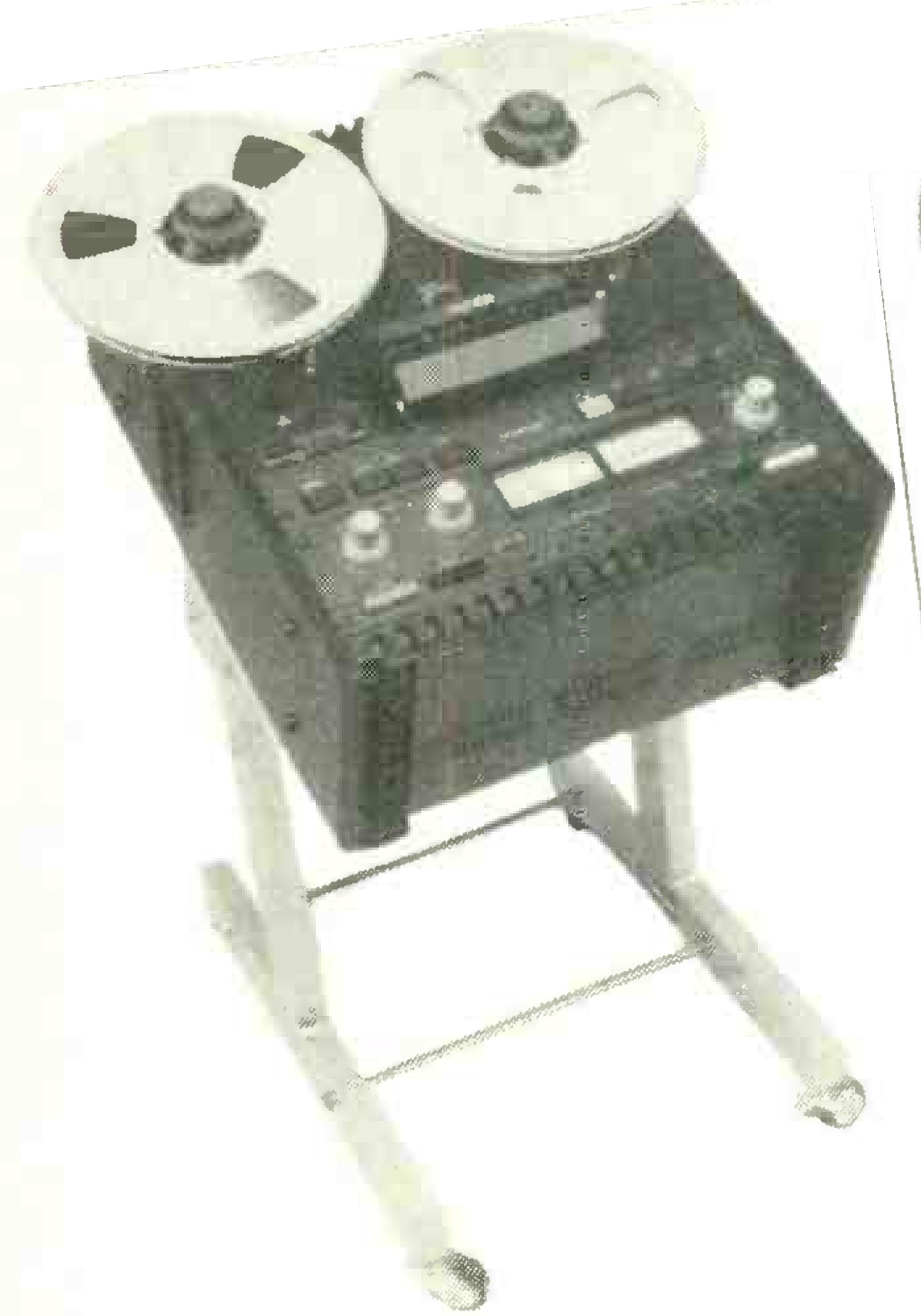 The MX5050B mounted tilted back on a tubular metal floor stand: two reels on the transport, the head cover, the two meters and the level knobs on the faceplate.