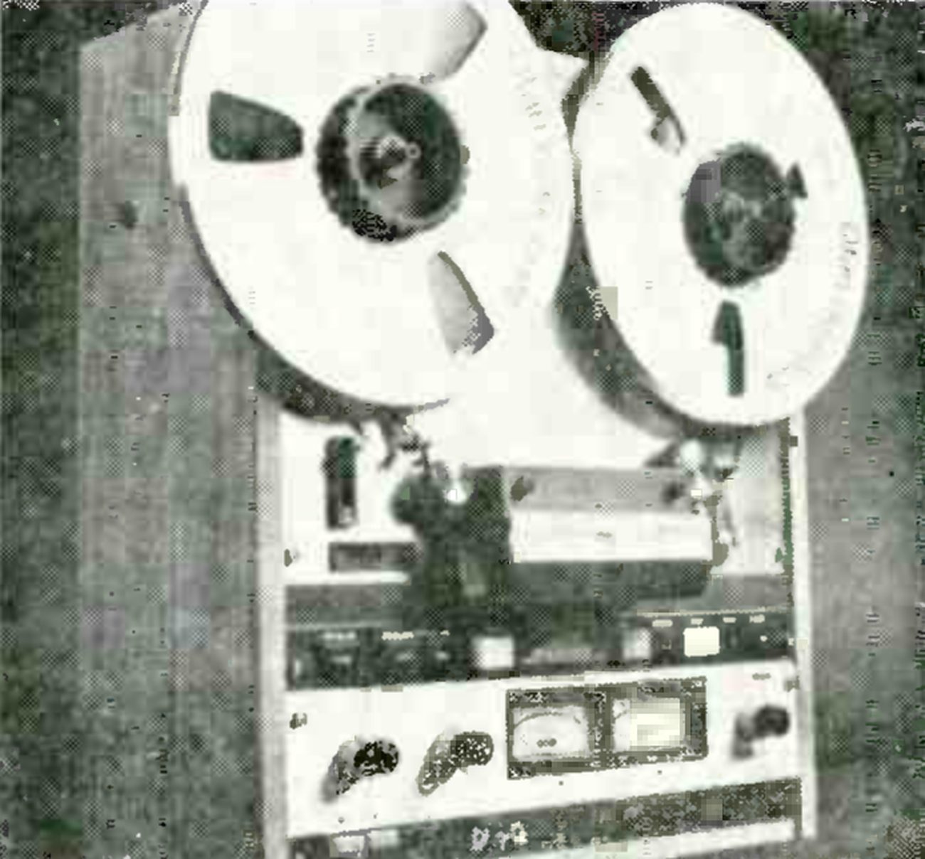 The upright MX5050 photographed head-on in its wooden side cheeks: two reels at the top, the head assembly and transport controls below them, and the electronics panel with two VU meters between the level knobs.