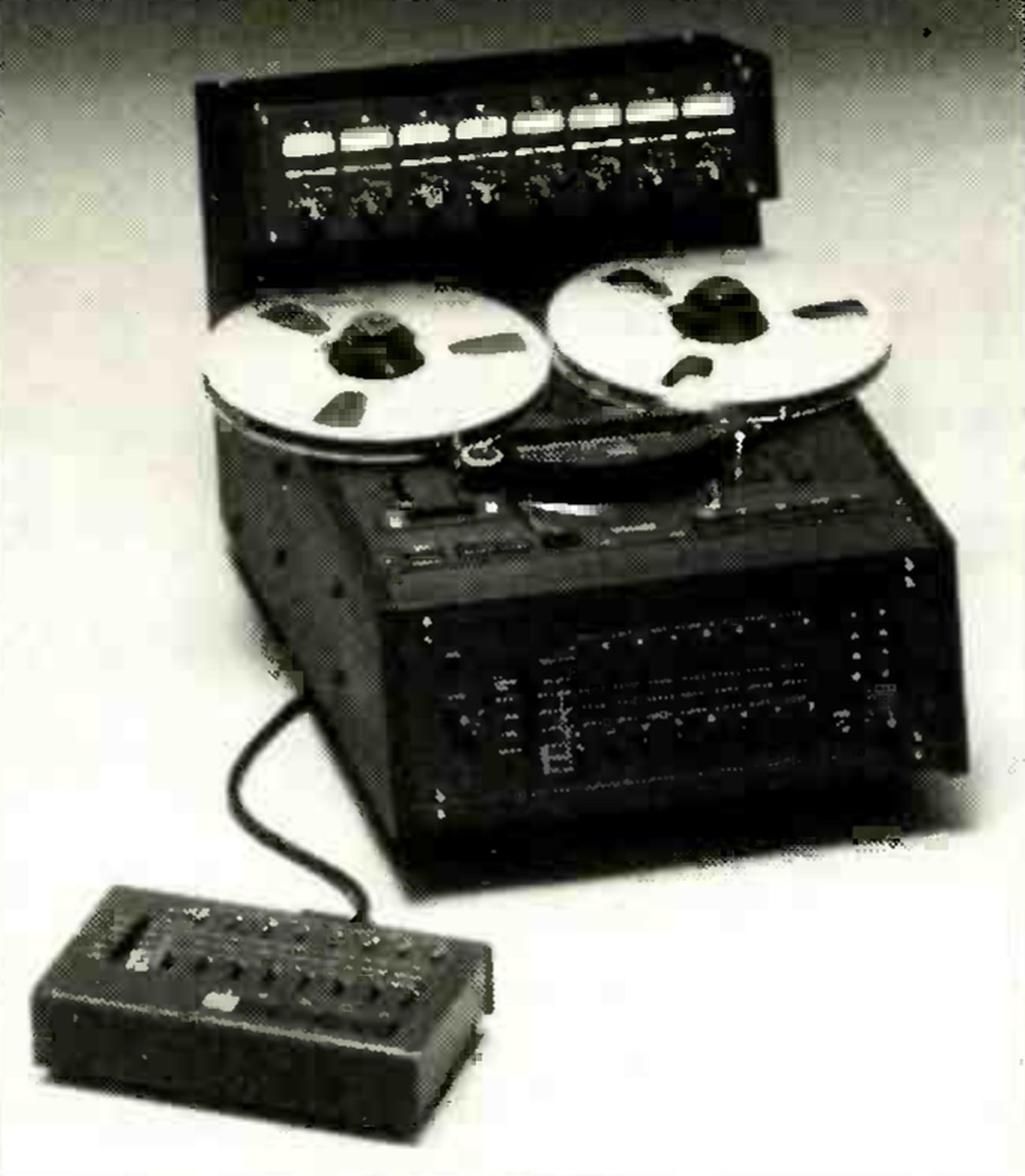 The MARK III/8 photographed from a high three-quarter angle: the desk-top cabinet with two large reels on the sloping transport, the eight-channel meter bridge standing above it, the electronics panel with its rows of channel controls on the front, and a cabled remote control unit with a row of keys in the foreground.