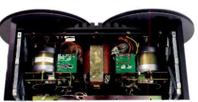 The inside of the machine with its head cover raised: two large reel motors at left and right, a shielded transformer at the centre, and green circuit boards mounted between them on the underside of the deck.
