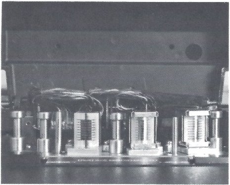 The three eight-track head stacks of the MX-5050-8 with the head cover removed: erase, record and reproduce in line on the head base, their wiring looping up behind them