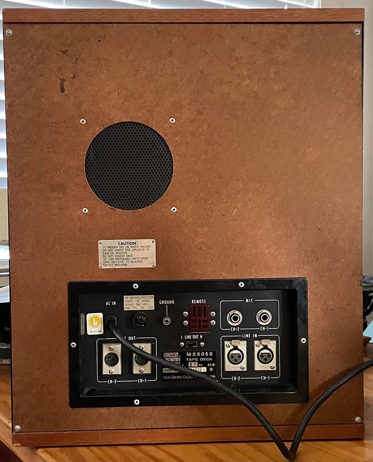 The factory walnut cabinet from behind — Klarion distributor sticker beside the AC inlet.