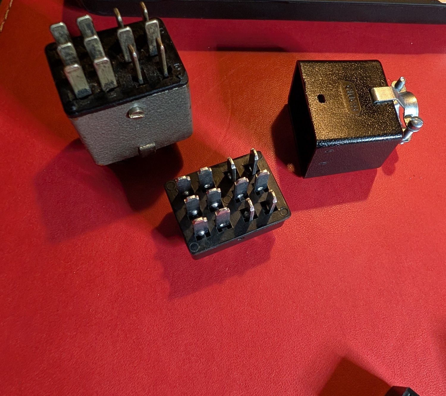 Cinch-Jones hardware, old and new — the vintage plug beside the modern body and hood.