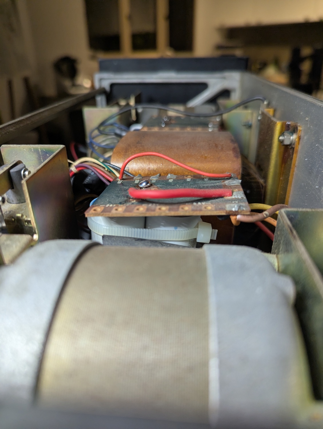 The paralleled 3 + 2.5 µF motor-run cans for a spindle motor, zip-tied beneath the voltage-selector board.